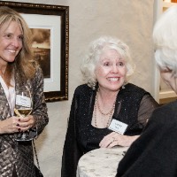 Three ladies chatting around a table